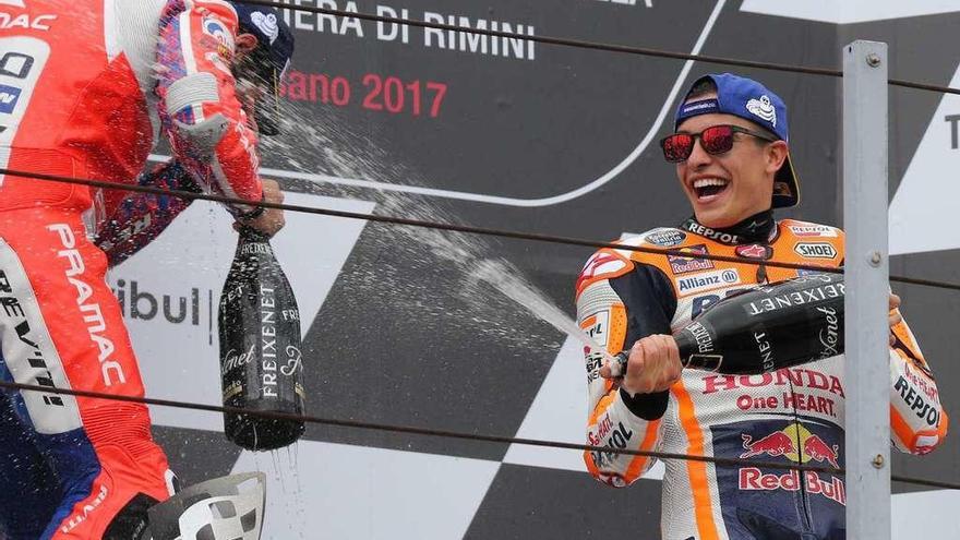 Marc Márquez riega en el podio de San Marino al italiano Danilo Petrucci.