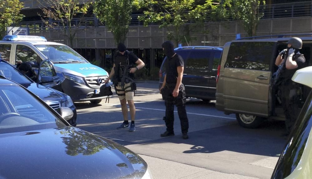 German special police leave their car after a ...