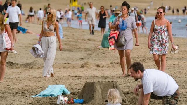 Turistas disfrutan de un día de sol en la Playa del Inglés, en Gran Canaria.