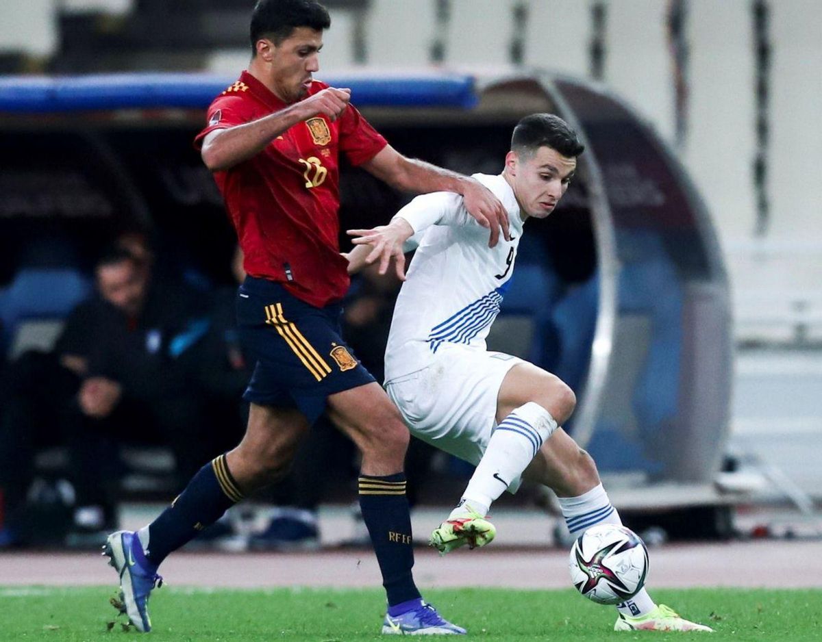 Douvikas protegeel balón ante Rodrien un partido con la selección griega. // Efe