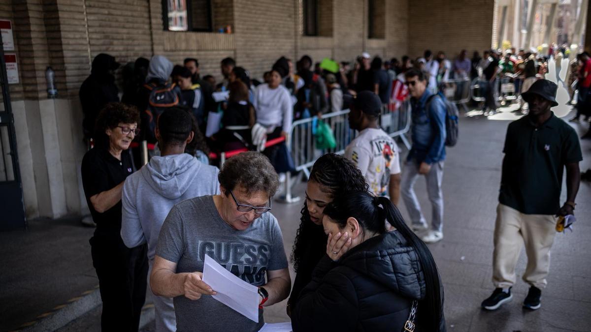 Fila de inmigrantes en las puertas del Ayuntamiento de Zaragoza, en una imagen de archivo.