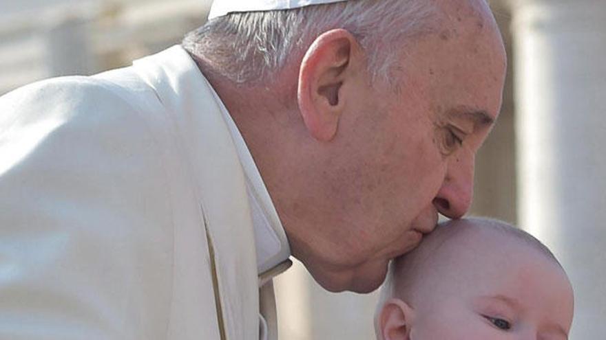 El Papa besa a un niño en el Vaticano.