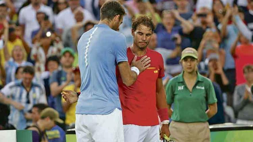 Del Potro consuela a Nadal tras derrotarlo en la semifinal del torneo individual.