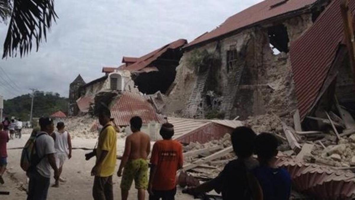 Varios filipinos observan la destrucción causada en la catedral de San Pedro, en Loboc (provincia de Bohol), este martes.