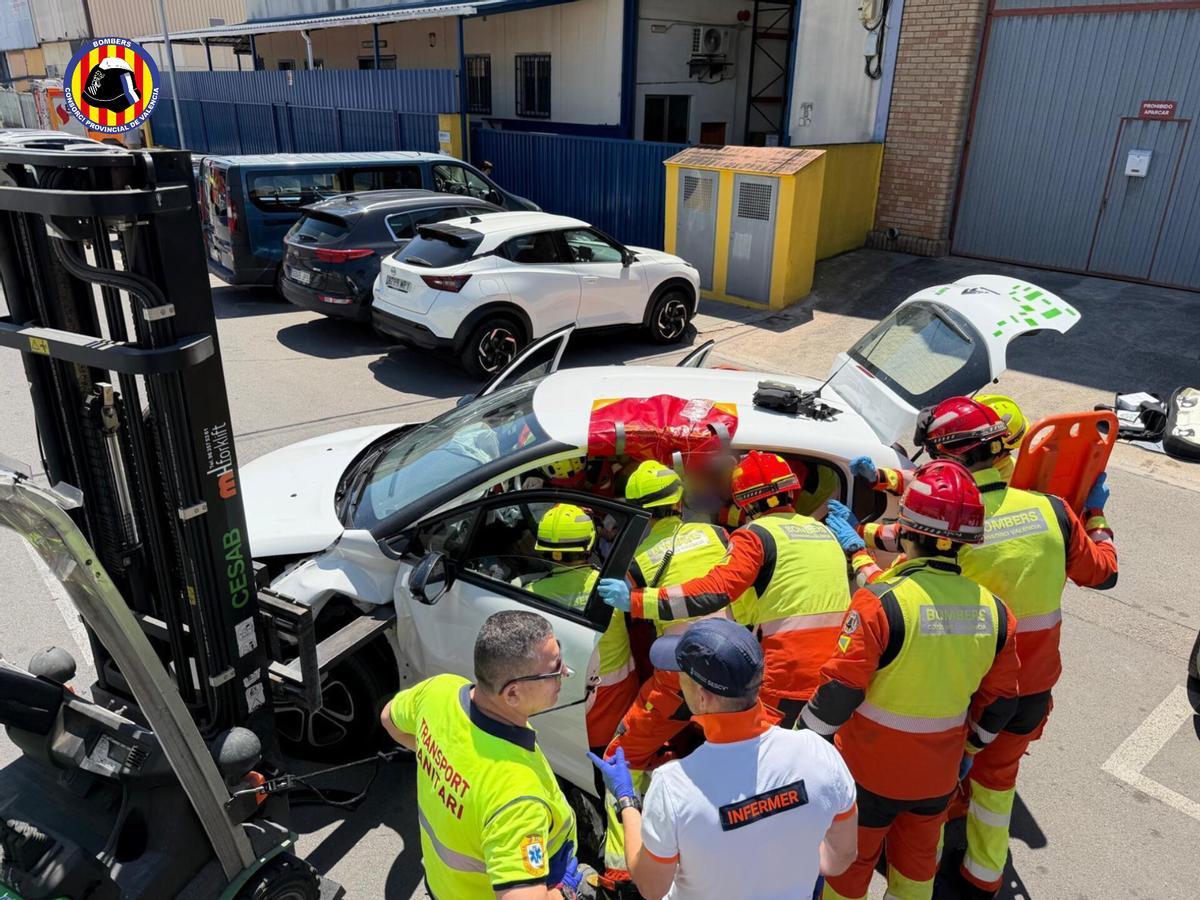 Los bomberos tratando de excarcelar al conductor del turismo.