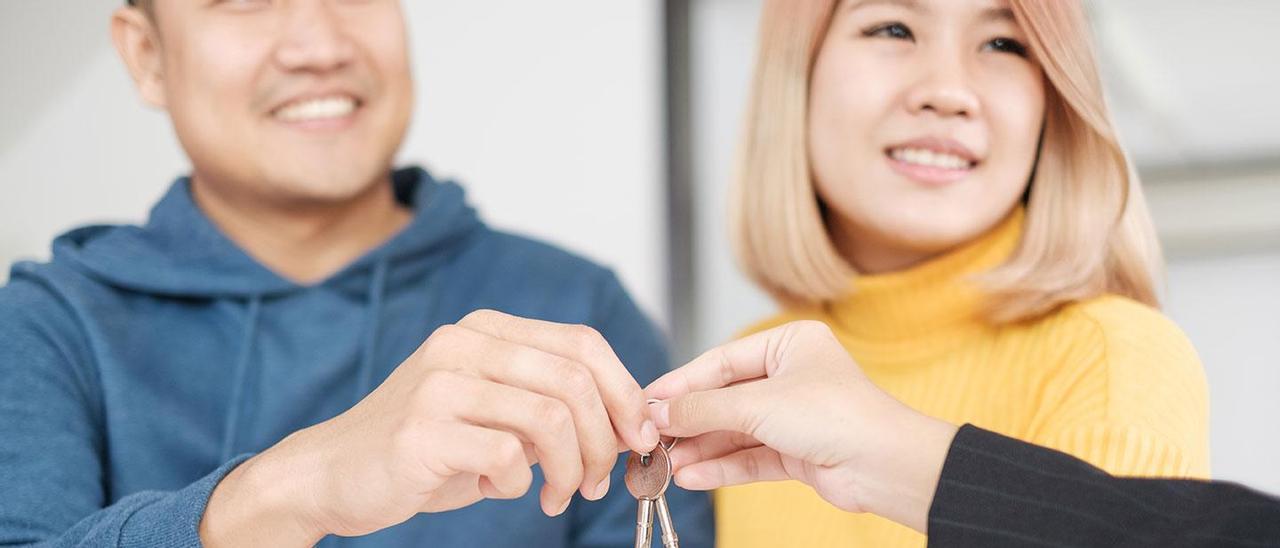 Una pareja asiática firmando el contrato de alquiler de un piso