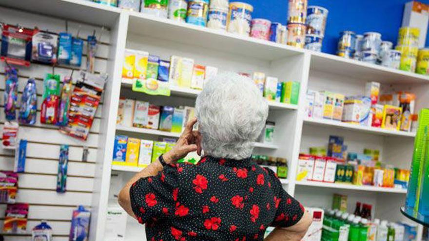 Una mujer espera su turno en la farmacia.