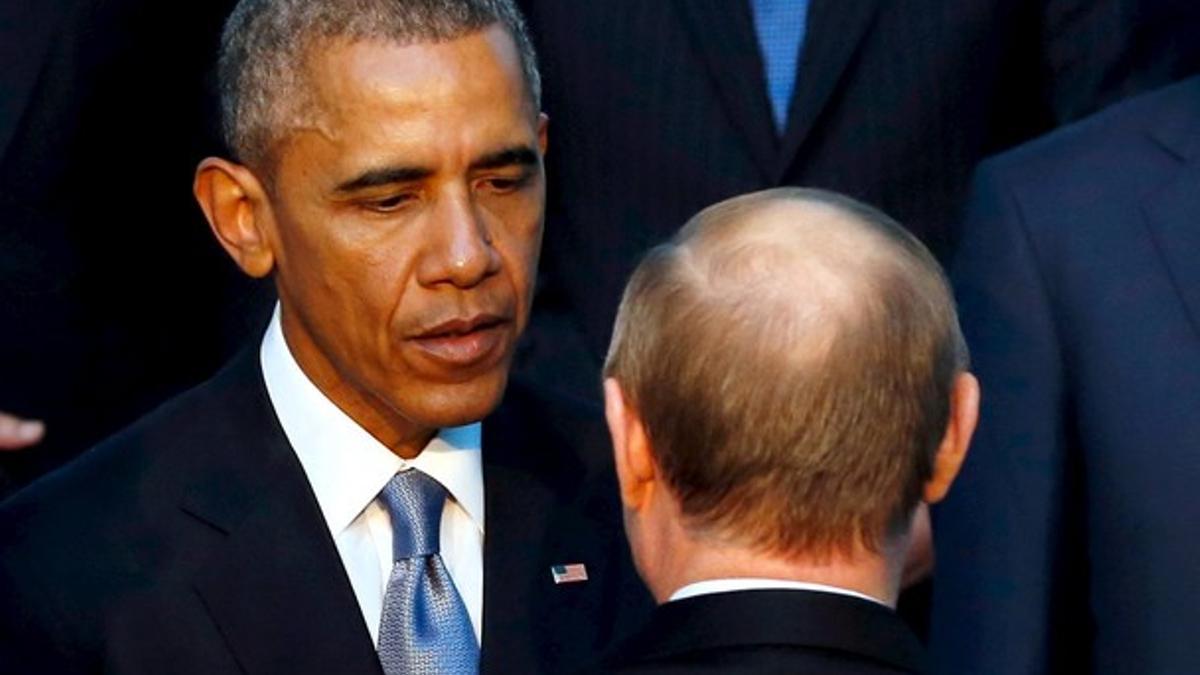 Barack Obama y Vladimir Putin hablan durante la foto de familia del G-20, este domingo en Antalya.