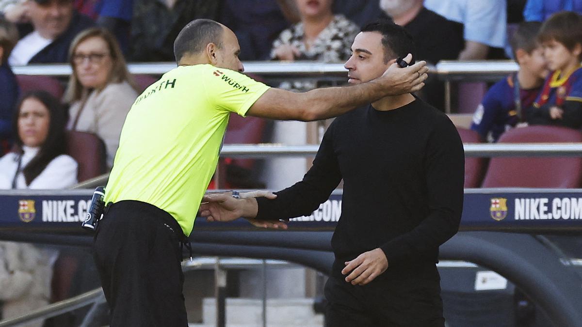 Mateu Lahoz y Xavi Hernández, durante el derbi en el Camp Nou.