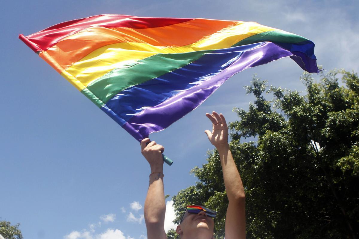 Un hombre agita una bandera LGBTI durante la marcha del orgullo gay.