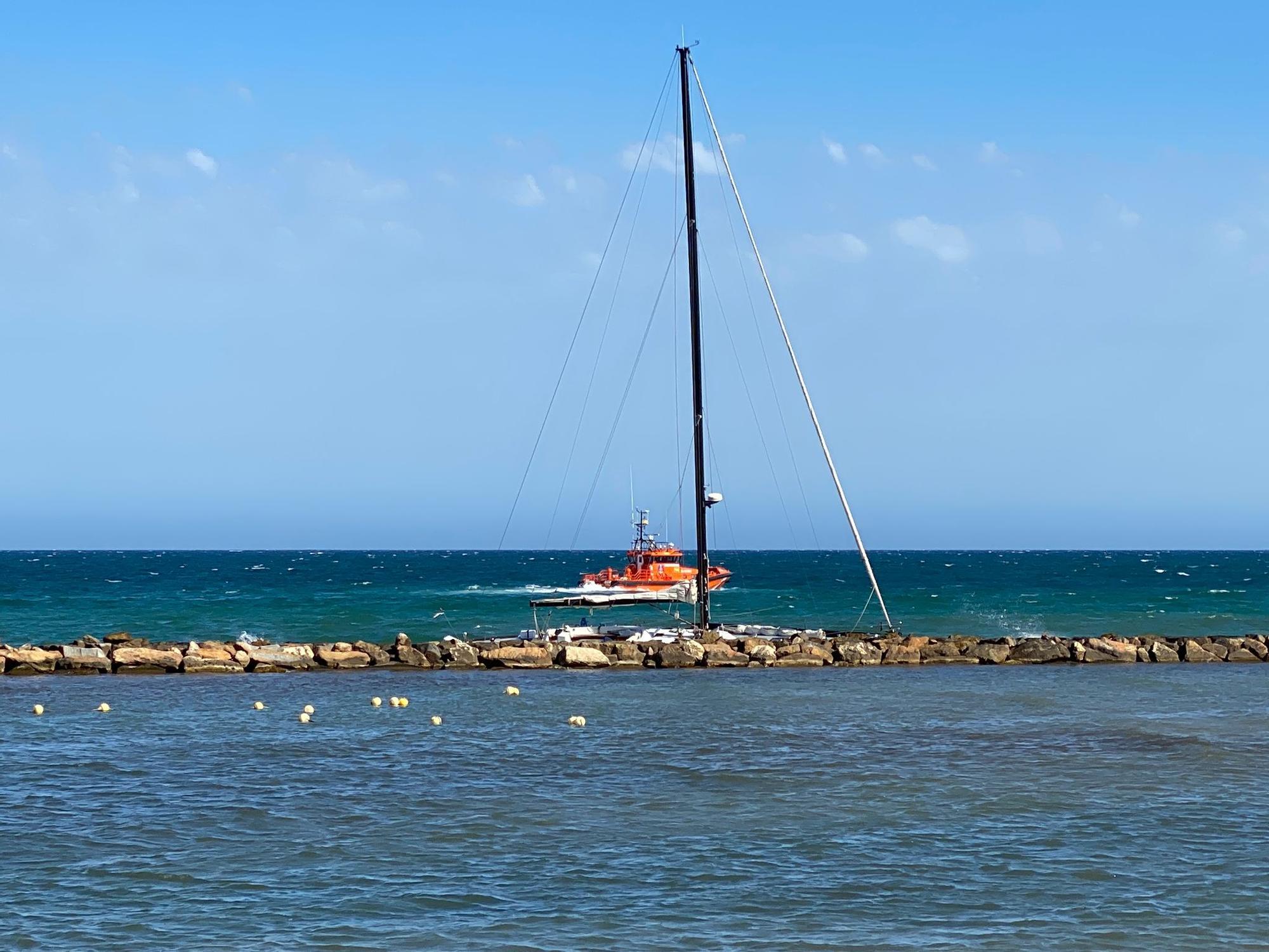 Un velero encalla en las rocas de la escollera de la playa del Cocó