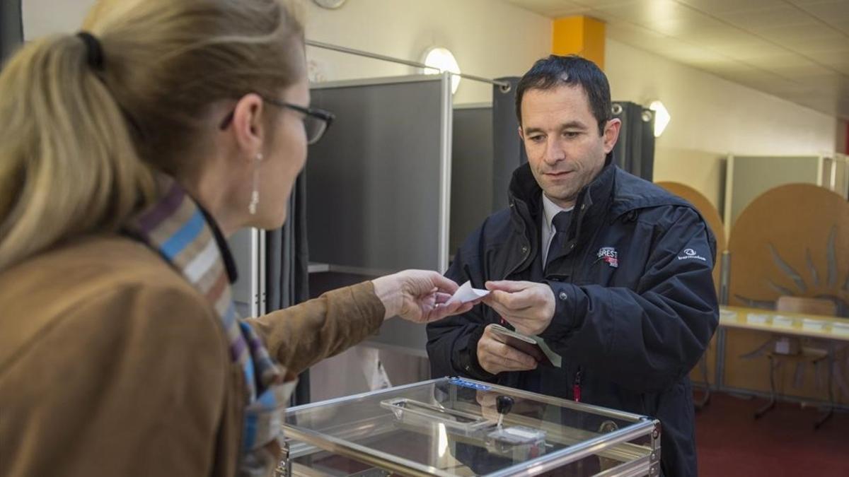 El antiguo ministro de Educación francés Benoit Hamon (derecha), en el momento de votar en las primarias, en París, el 22 de enero.