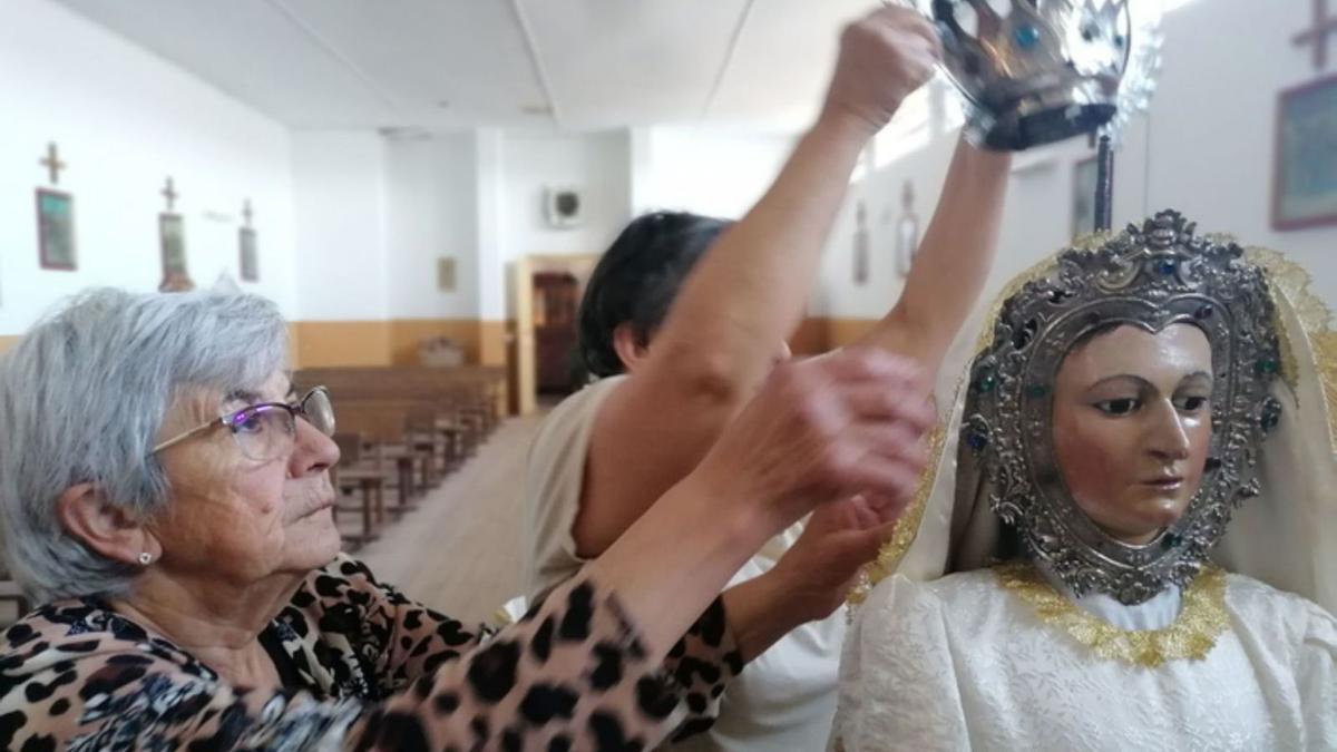 Dos mujeres de San Román del Valle vistiendo a la Virgen. | E. P.