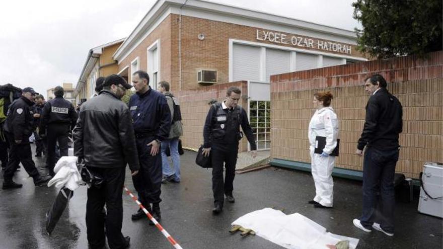 Agentes policiales, junto al lugar donde cayó uno de los cuerpos. | efe