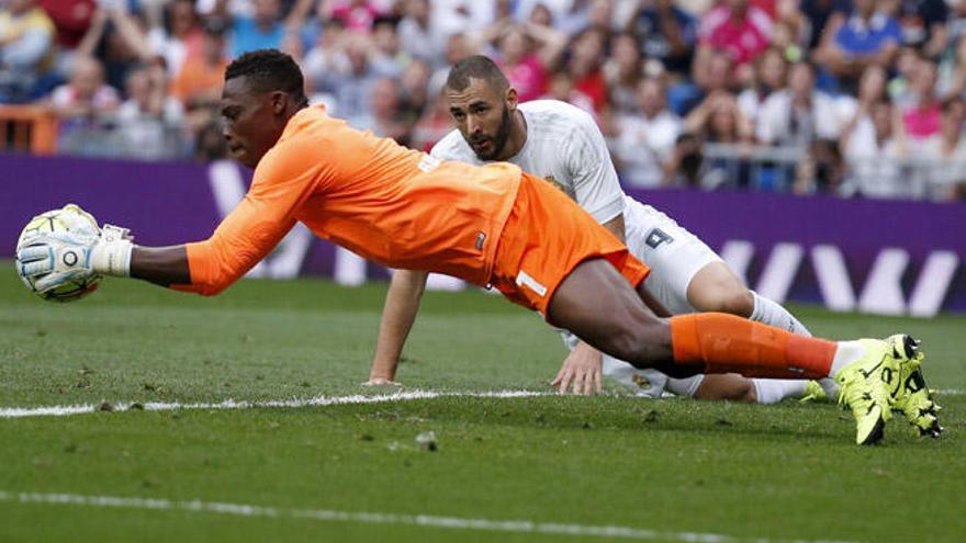 El meta camerunés Kameni atrapa el balón en presencia de Karim Benzema.