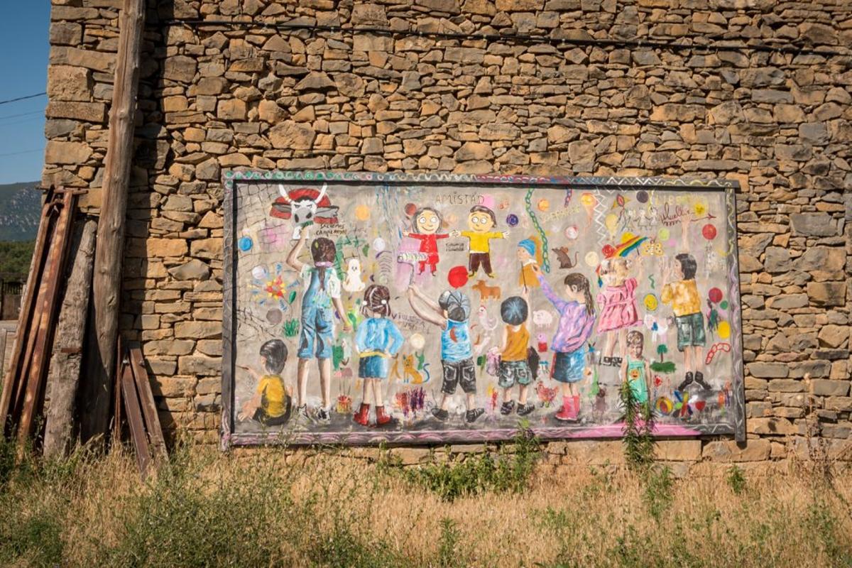 Un mural de Arcusa en el que se ven a unos niños pintando una pared