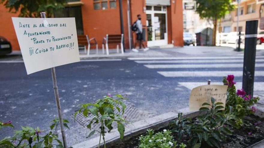 Las jardineras, con letreros que reivindican el trabajo de los vecinos ante la pasividad municipal