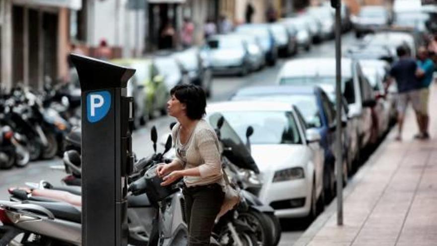 Una usuaria de la zona azul abona su recibo en una calle del centro de la ciudad.