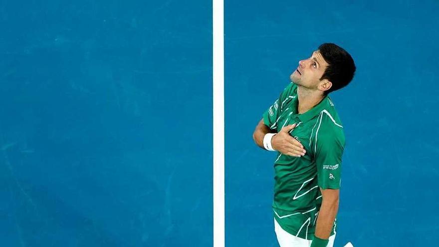 Djokovic mira al cielo tras conseguir la victoria ante Thiem. // Efe