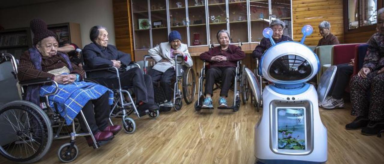 Ancianos chinos interactúan con un robot en un centro de asistencia social