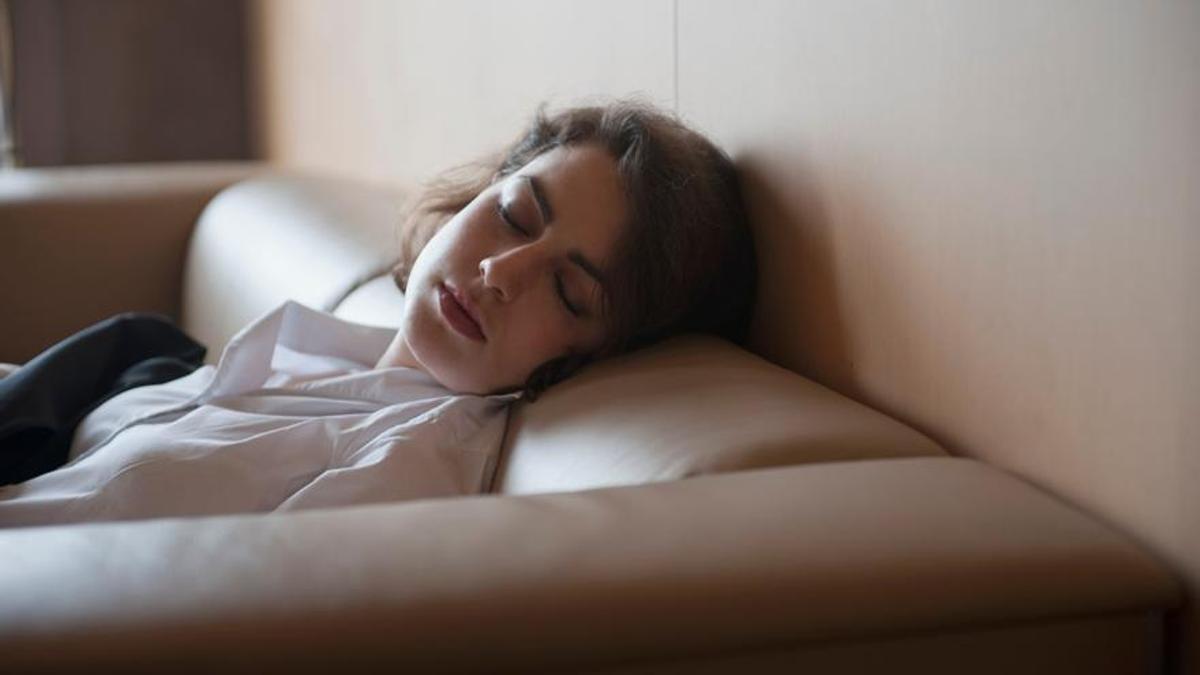 Una mujer echando una siesta en el sofá