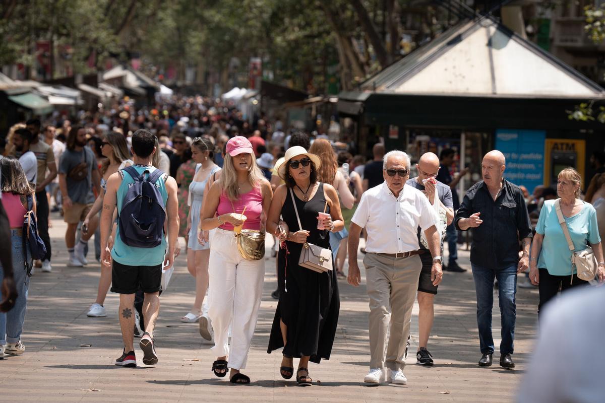 Varias personas pasean por Las Ramblas, a 30 de junio de 2023, en Barcelona, Cataluña (España).