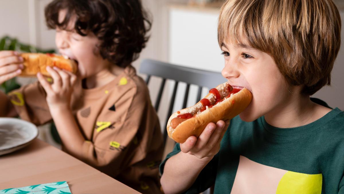 ninos comiendo hot dogs juntos