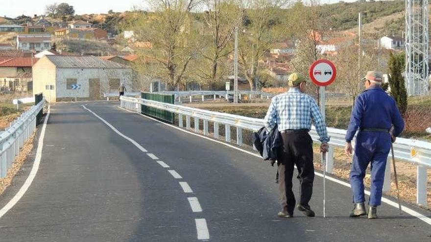 Vecinos en la carretera de acceso a Villanueva de las Peras