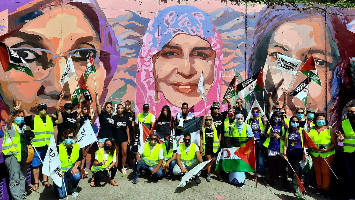 Los participantes de la marcha por la libertad del Pueblo Saharaui del día 13 de junio (columna norte) ante un mural que reivindica el papel fundamental de la mujer saharaui, ubicado en la Laguna.