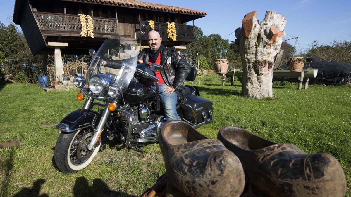 Víctor Manuel Suárez, presidente de Amigos del Hórreo, con su Harley, delante de una panera en Busto de Gozón.  | M. L.