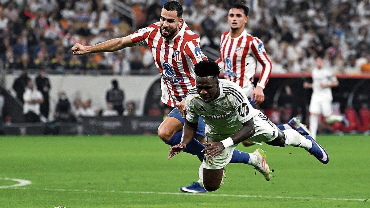 Vinicius, delantero del Real Madrid, cae durante su duelo frente al Atlético en Yeda.