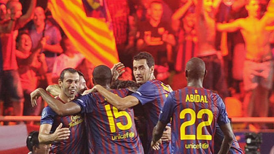 Los jugadores del Barcelona celebran un gol en la Supercopa de Europa mientras sus aficionados exhiben bengalas.