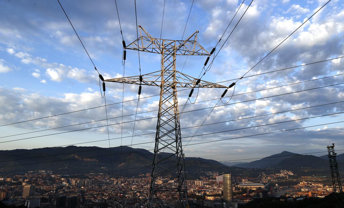 Una torre de transporte de energía perteneciente a red eléctrica, con la ciudad de Bilbao al fondo