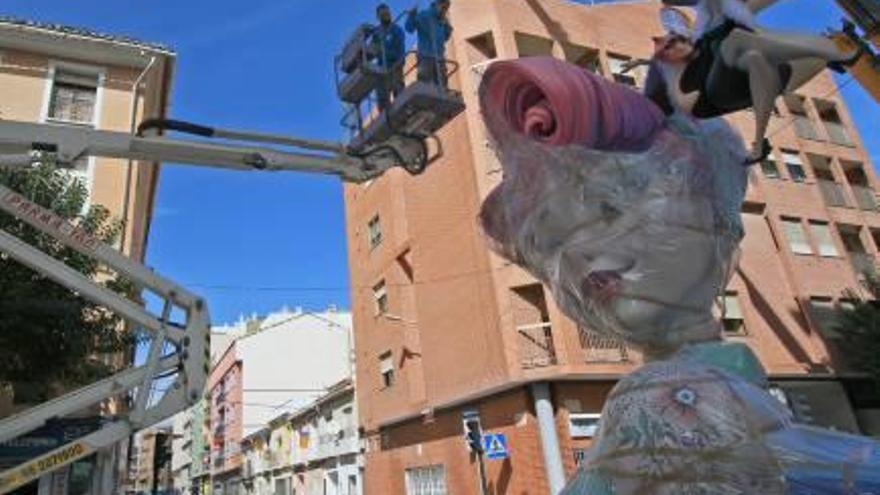 Dos de los artistas retiran el plástico a un «ninot» de Màrtirs.