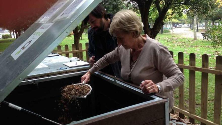 Una mujer deposita los residuos en el compostero. // FdV