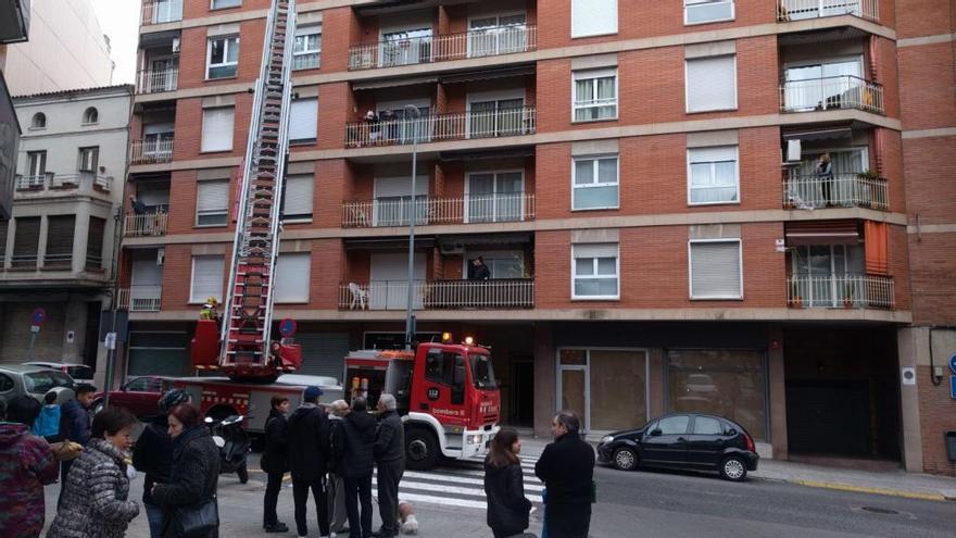 Agents dels Bombers accedint al pis de la víctima amb una grua, aquest matí