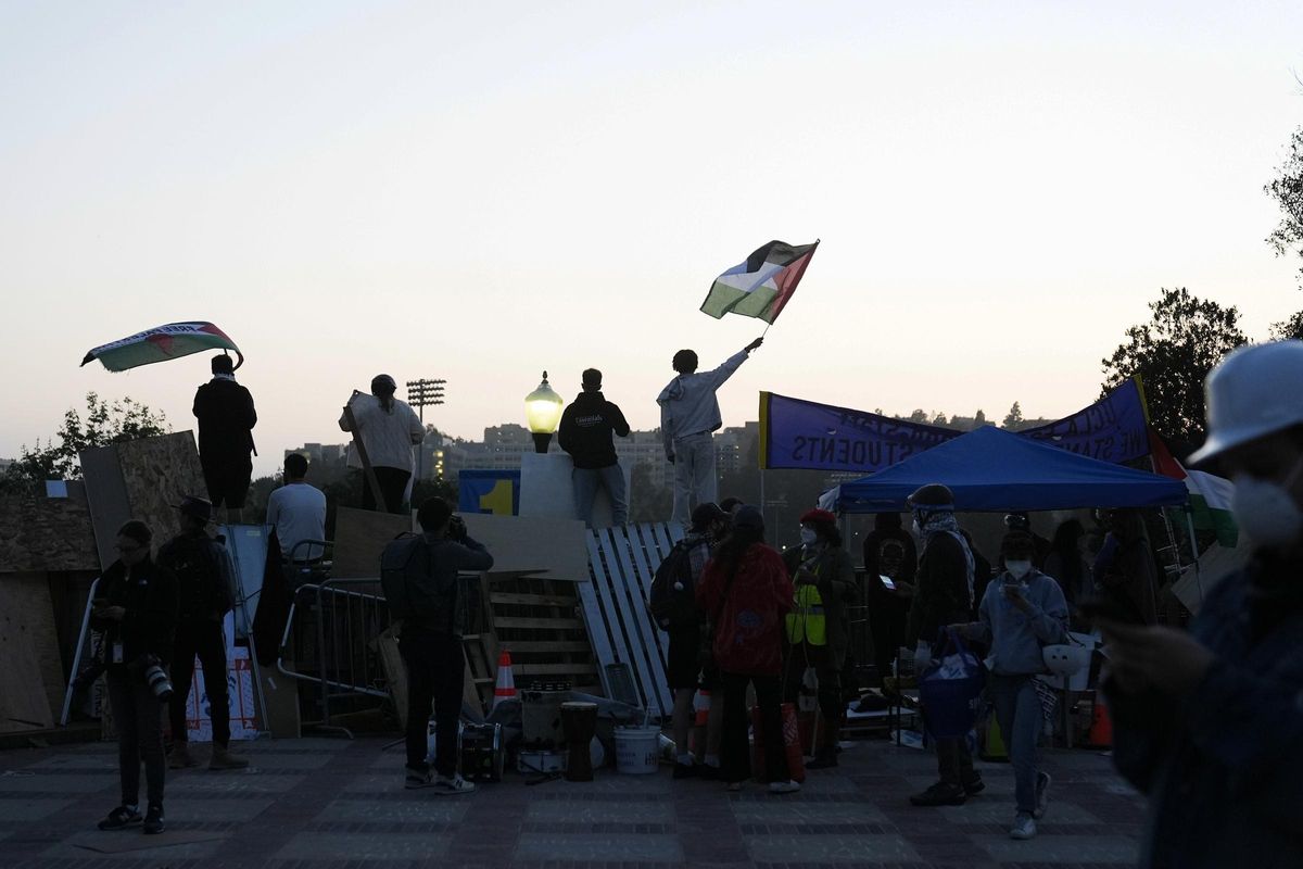 Pro-Palestinian demonstrators wave flags at an encampment on the UCLA campus Wednesday, May 1, 2024, in Los Angeles. (AP Photo/Jae C. Hong)