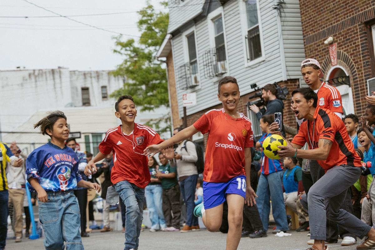Un grupo de niños juega a fútbol en las calles de Nueva York.