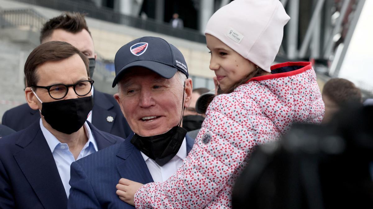 Joe Biden, con una niña en un campo de refugiados ucranianos en Polonia.