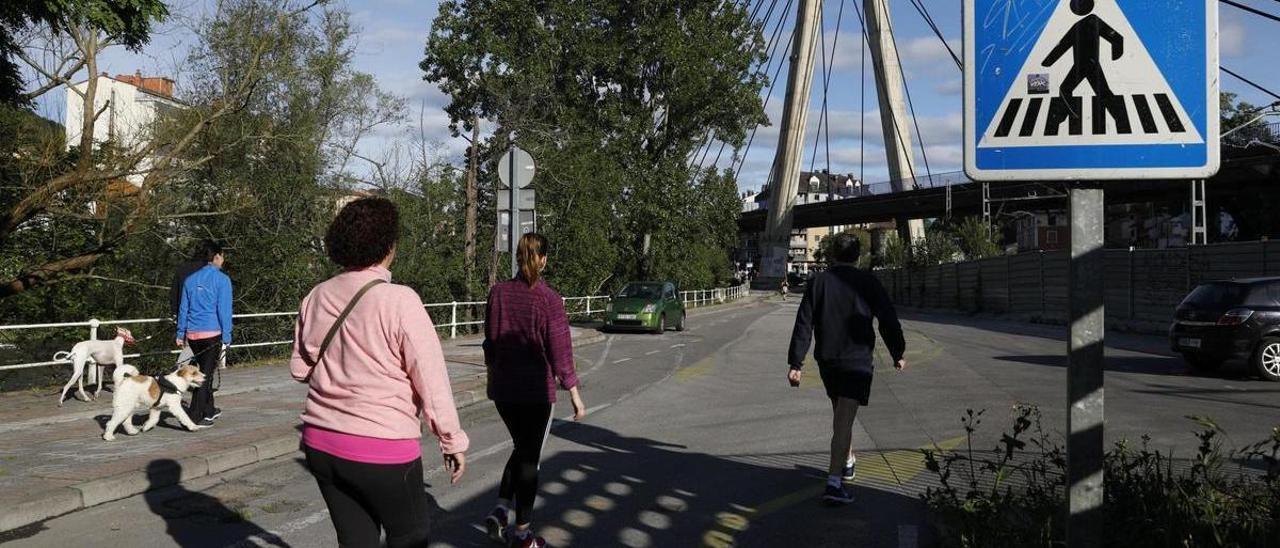 Vecinos paseando junto al río Nalón, en Langreo.