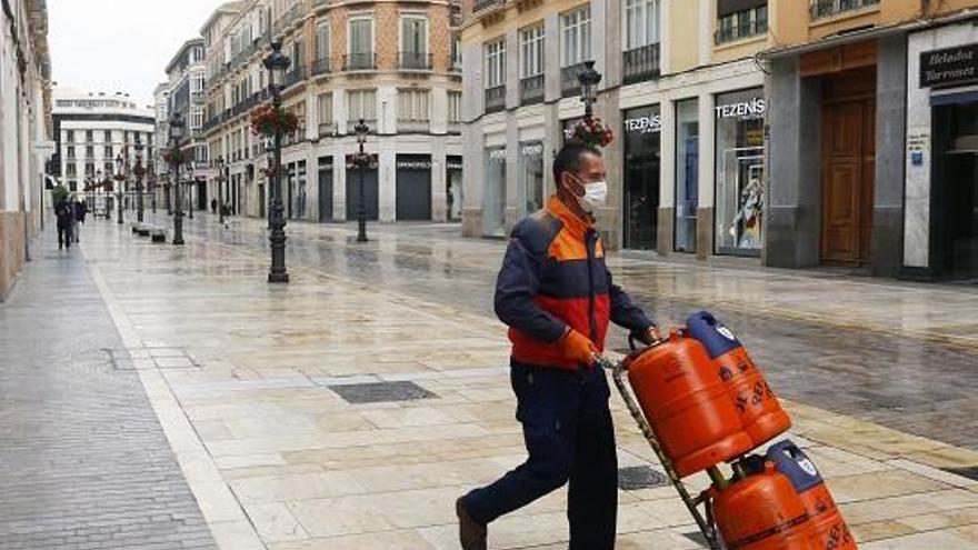 Un trabajador lleva una mascarilla en calle Larios para protegerse del coronavirus.