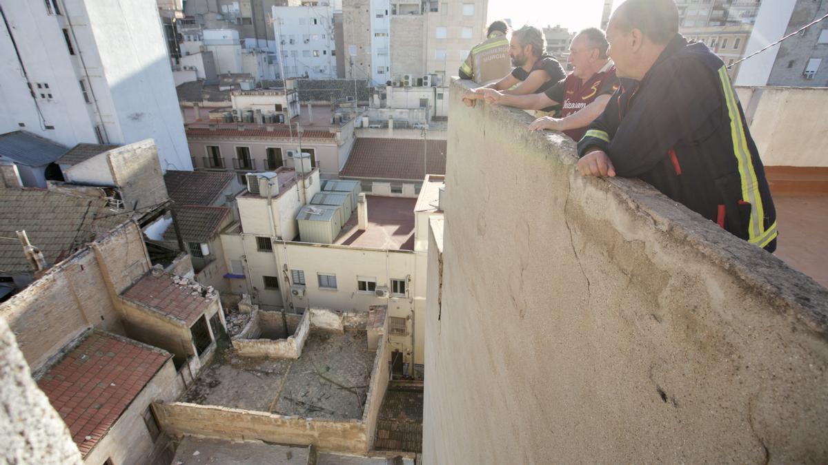 Varios vecinos indican a los bomberos dónde ha ocurrido el desprendimiento