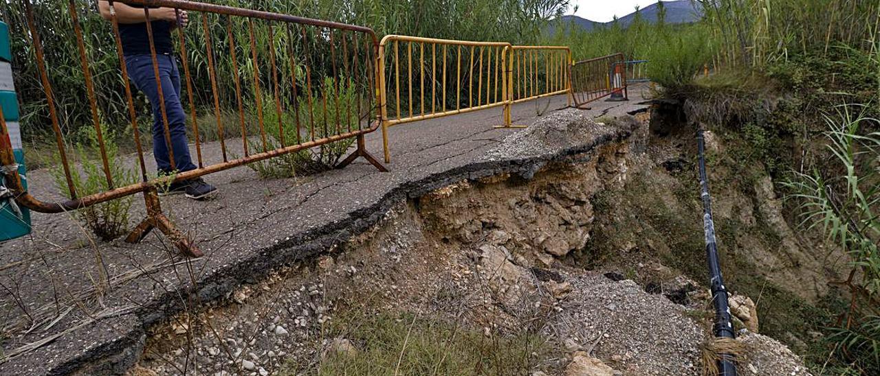 Desprendimiento provocado por la borrasca Gloria en la partida Almoroig de Muro; a la derecha, el propietario de la finca afectada señala los destrozos en la parcela. | JUANI RUZ