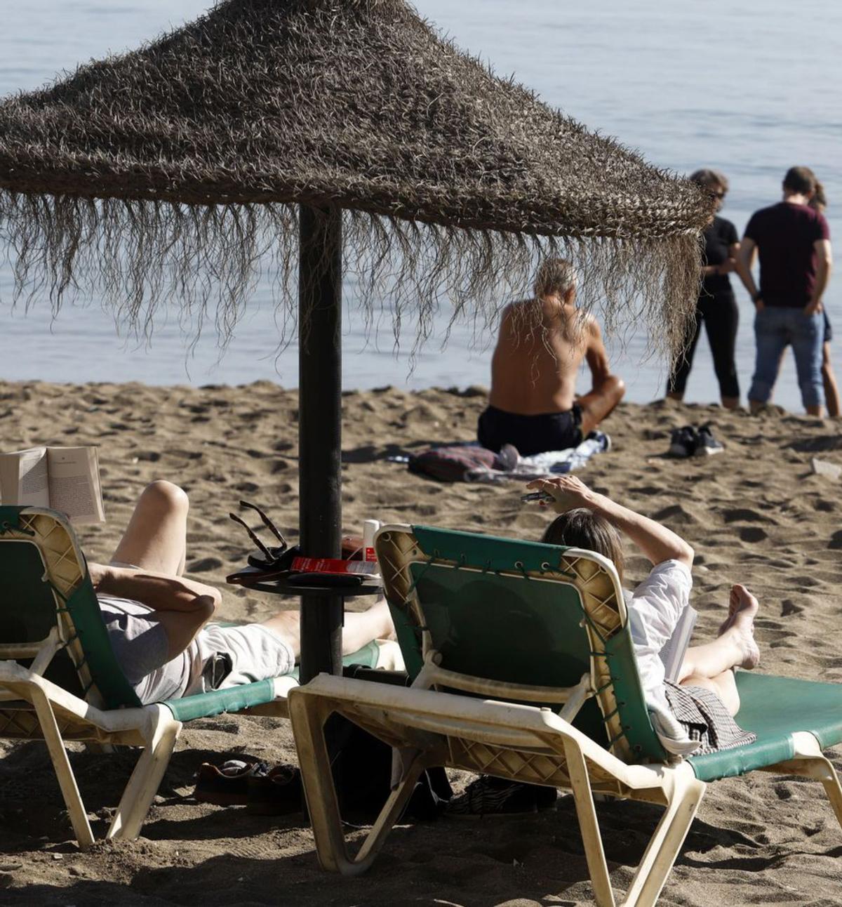 Turistas en hamacas en la playa de la Malagueta. | ÁLEX ZEA