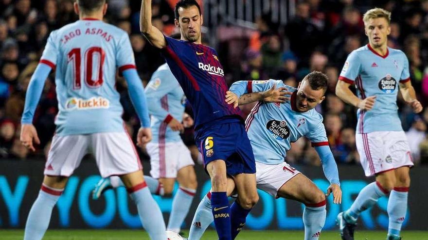 Lobotka pelea por el balón con Busquets, junto a Aspas y a Wass, el jueves en el Camp Nou. // LOF