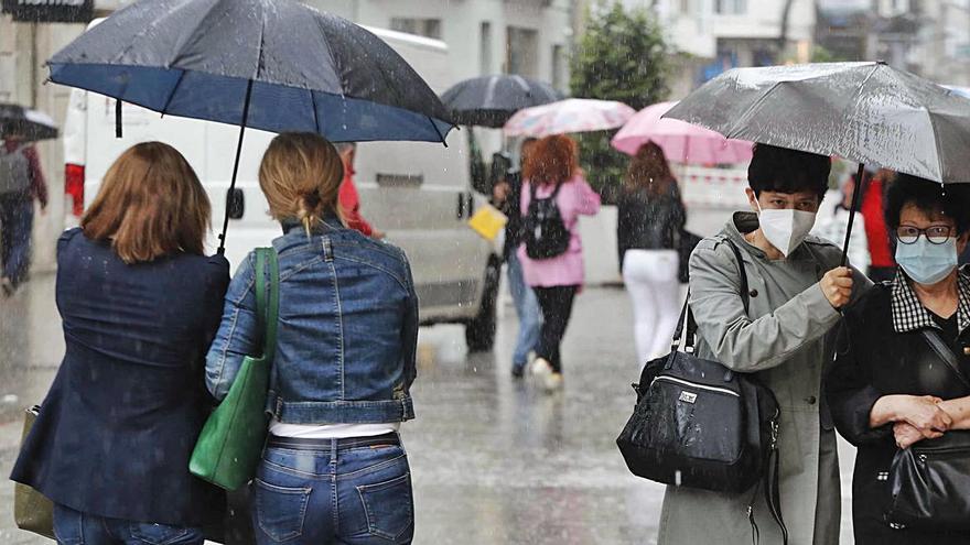 Viandantes a su paso por la céntrica calle Príncipe protegiéndose de la lluvia.   | // PABLO HERNÁNDEZ