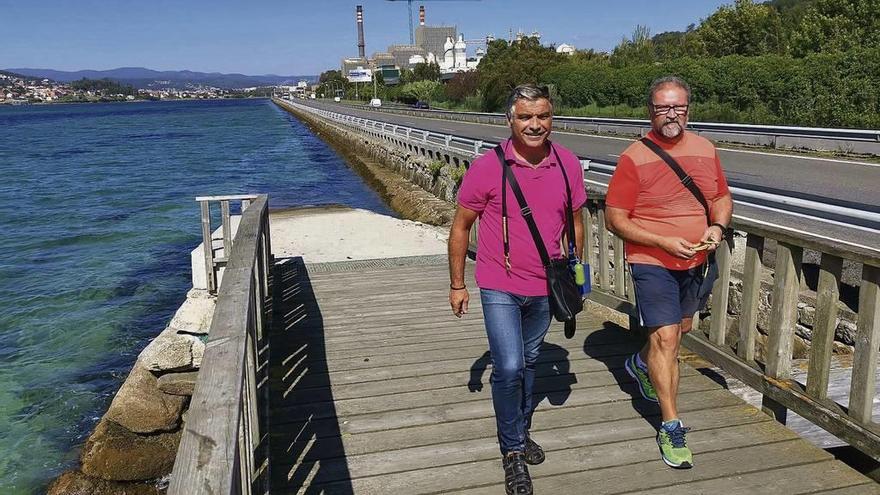 Dos hombres pasean por la &quot;pasarela de mariscadoras&quot; de Placeres, con la que se enlazará el nuevo paseo, por un margen de la PO-11. // S.A.