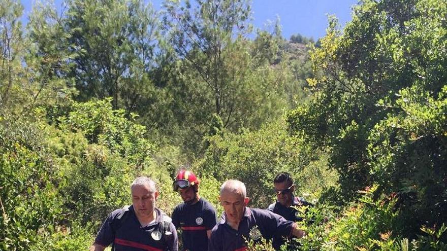 Los bomberos trasladan al senderista herido hasta una ambulancia para su traslado al hospital.