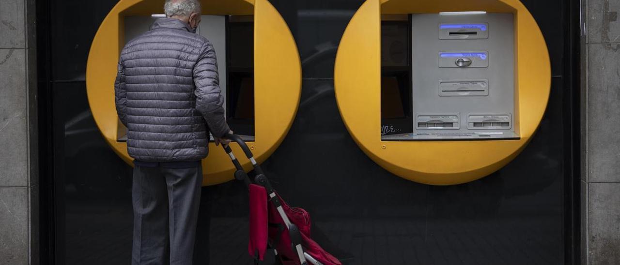 Un jubilado sacando dinero de un cajero automático.