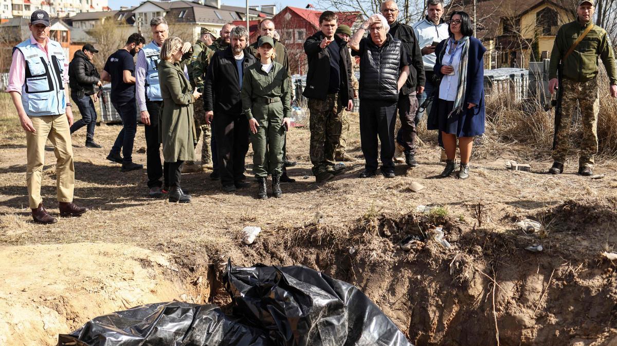 El jefe de ayuda humanitaria de la ONU, Martin Griffiths (quinto der.), reacciona en el sitio de una fosa común que los ucranianos habían cavado cerca de una iglesia el 7 de abril de 2022 durante su visita de tres horas en Bucha, un día después de visitar Moscú, donde se reunió con funcionarios. para discutir la situación humanitaria en Ucrania, más de un mes después de la invasión rusa. - Griffiths dijo que los investigadores investigarían las muertes de civiles descubiertas después de la retirada de las tropas rusas. La evidencia de asesinatos de civiles en Bucha y otras ciudades alrededor de Kiev, que Ucrania ha atribuido a las tropas rusas, acusaciones negadas por Moscú, ha conmocionado al mundo y ha desencadenado pedidos de nuevas sanciones contra Moscú.